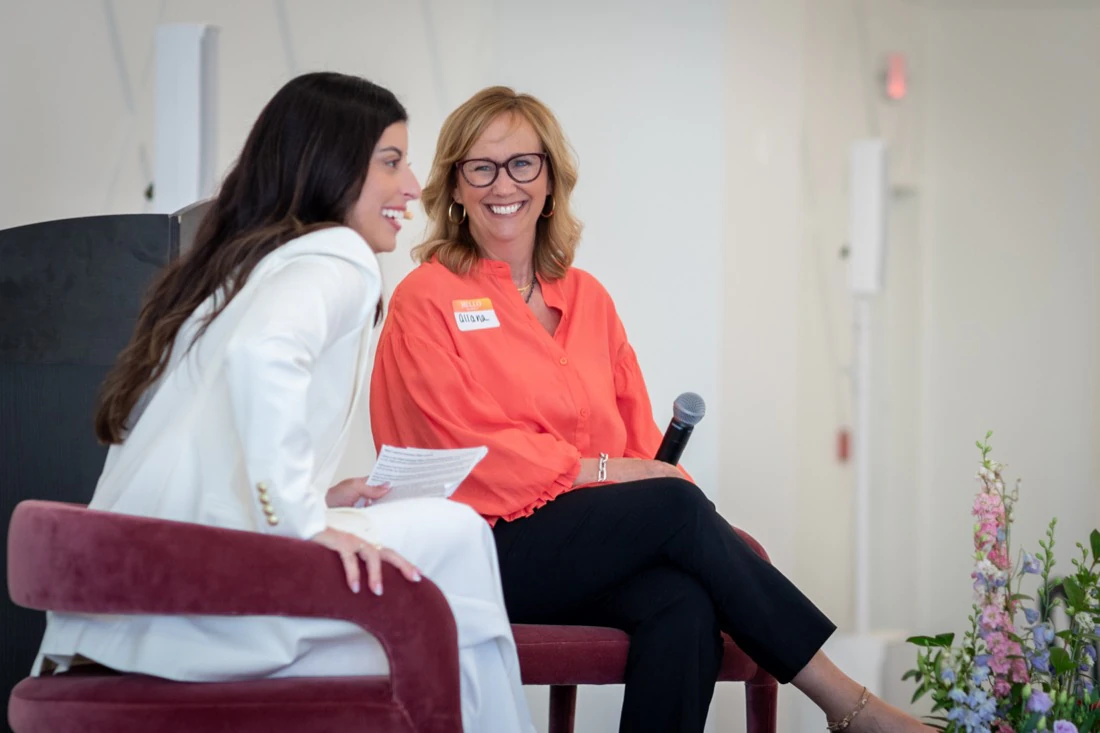 Alana laughing on stage with a guest during a Give Yourself Permission conversation.